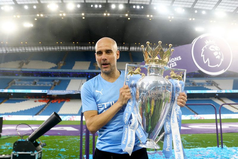 Pep Guardiola, the Manchester City manager, celebrates with the trophy after winning the Premier League last season