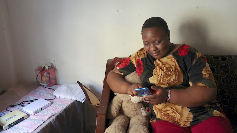 Kenyan migrant worker, Noel Musanga, uses her mobile phone in her apartment in Burj Hammoud, Lebanon