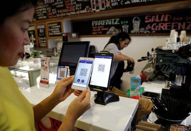 A woman pays for her coffee with crypto at a cashless cafe in Singapore