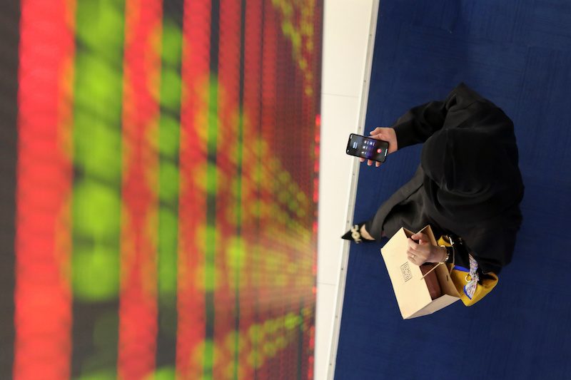 A woman uses her mobile at Dubai Financial Market. Savers can now invest in IPOs via a banking app