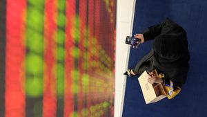 A woman uses her mobile at Dubai Financial Market. Savers can now invest in IPOs via a banking app