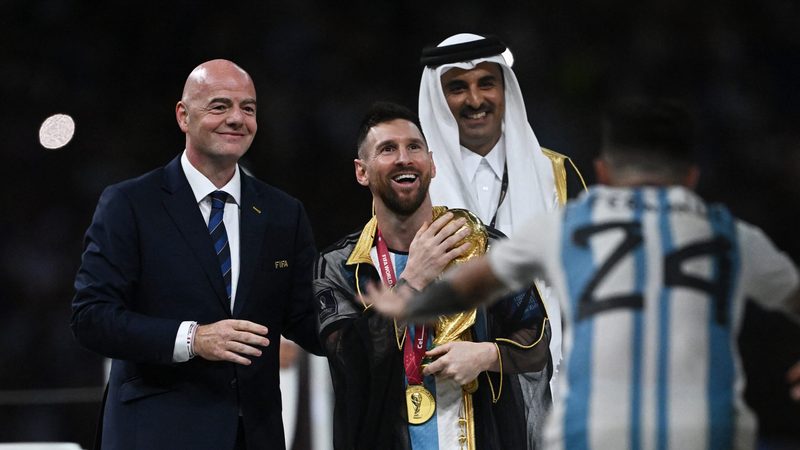 Lionel Messi accepts the World Cup trophy from the emir of Qatar Sheikh Tamim bin Hamad Al Thani and Fifa president Gianni Infantino after Argentina defeated France on penalties at the Lusail Stadium