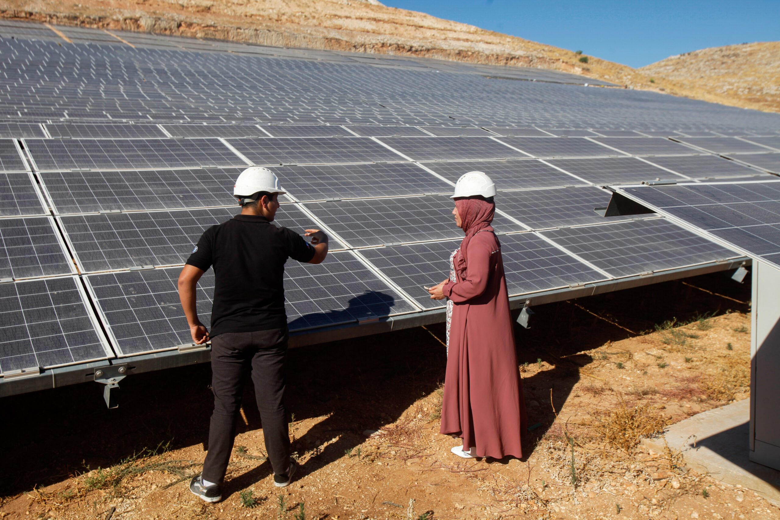 solar panels, woman, man, helmet