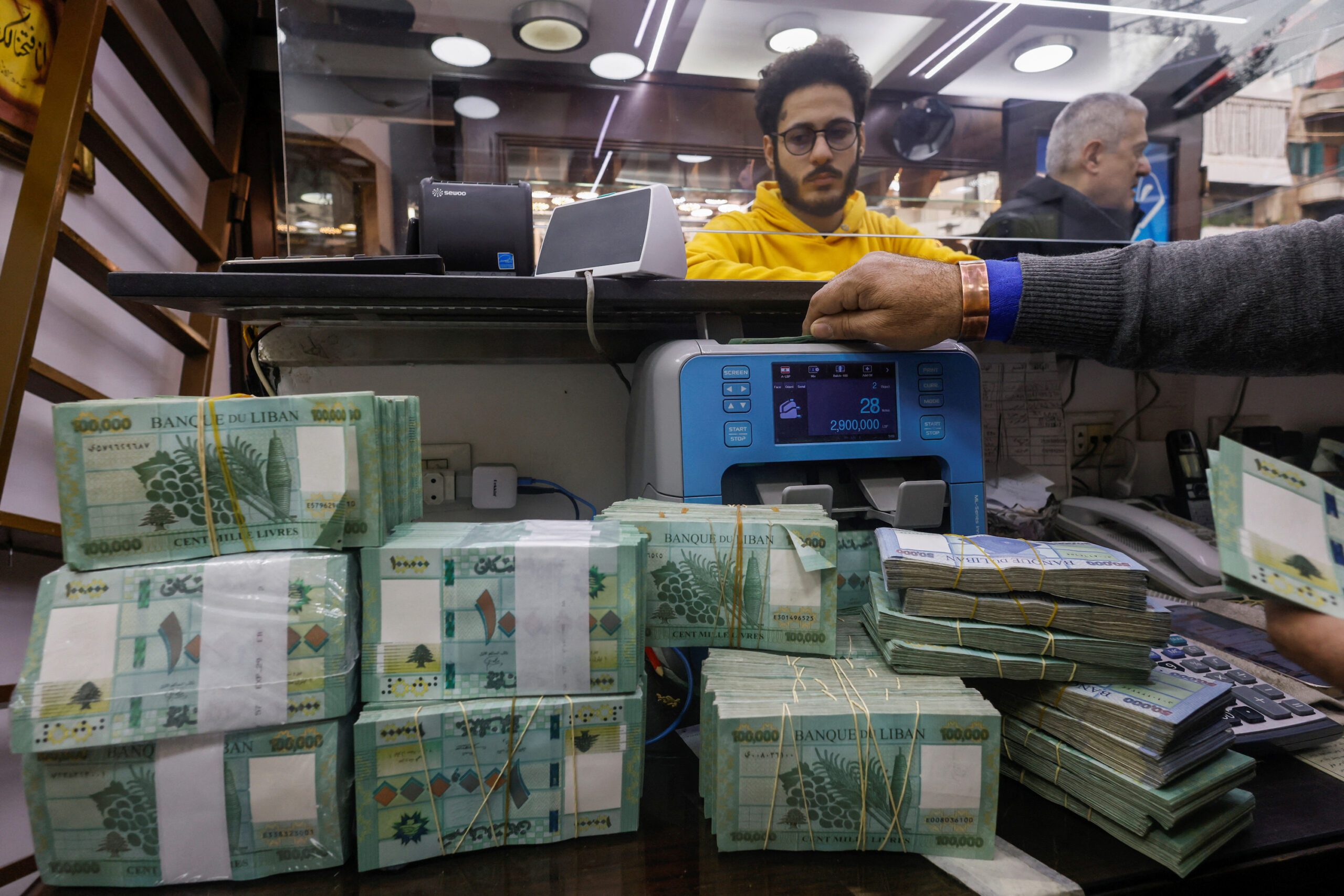 A man counts Lebanese pound banknotes at an exchange shop in Beirut