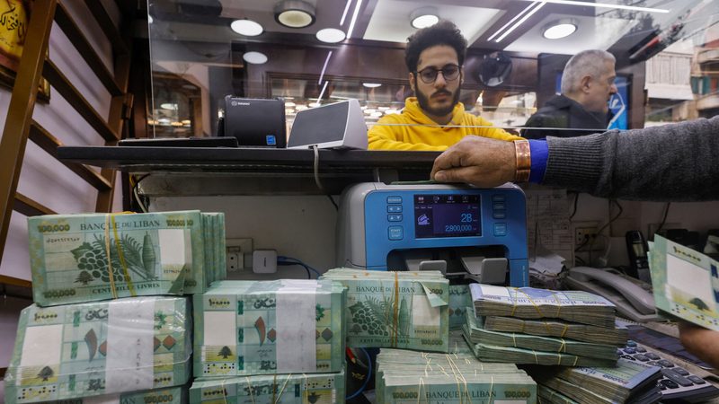 A man counts Lebanese pound banknotes at an exchange shop in Beirut