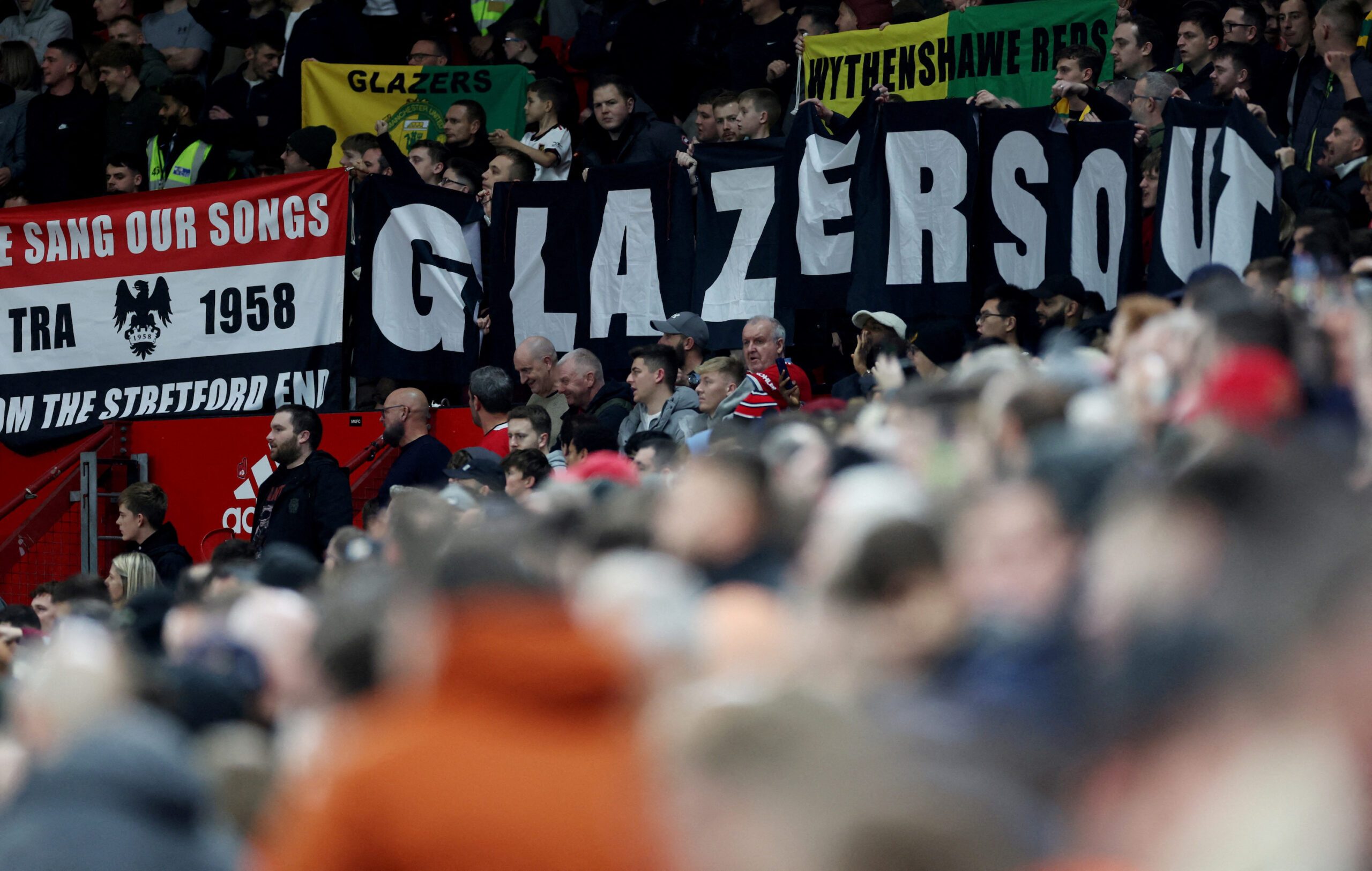 Manchester United fans display banners in protest of the Glazer family’s ownership of the club