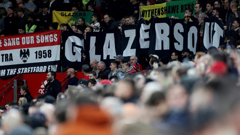 Manchester United fans display banners in protest of the Glazer family’s ownership of the club