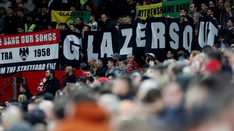 Manchester United fans display banners in protest of the Glazer family’s ownership of the club