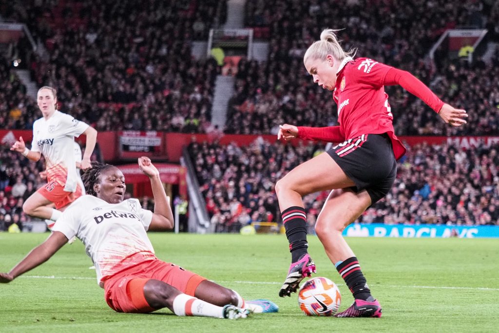 Hawa Cissoko of West Ham slides in on Alessia Russo of Manchester United, giving away a penalty during the Womens Super League game at Old Trafford on March 25