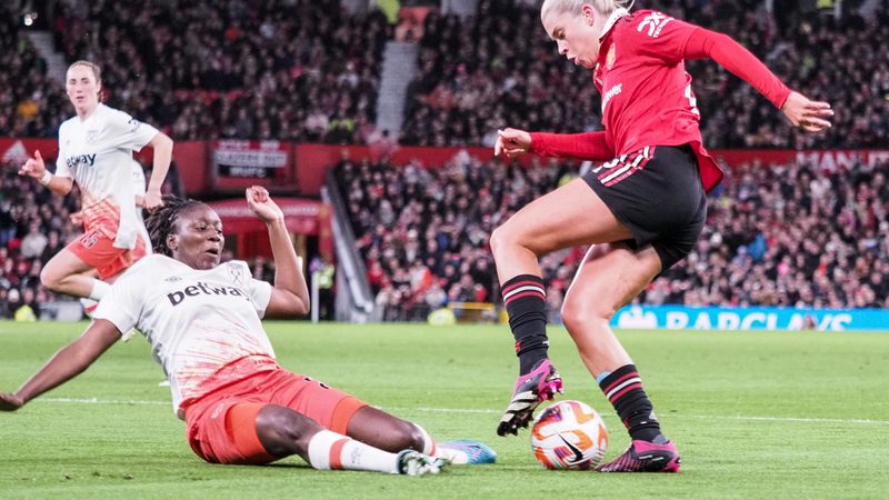 Hawa Cissoko of West Ham slides in on Alessia Russo of Manchester United, giving away a penalty during the Womens Super League game at Old Trafford on March 25