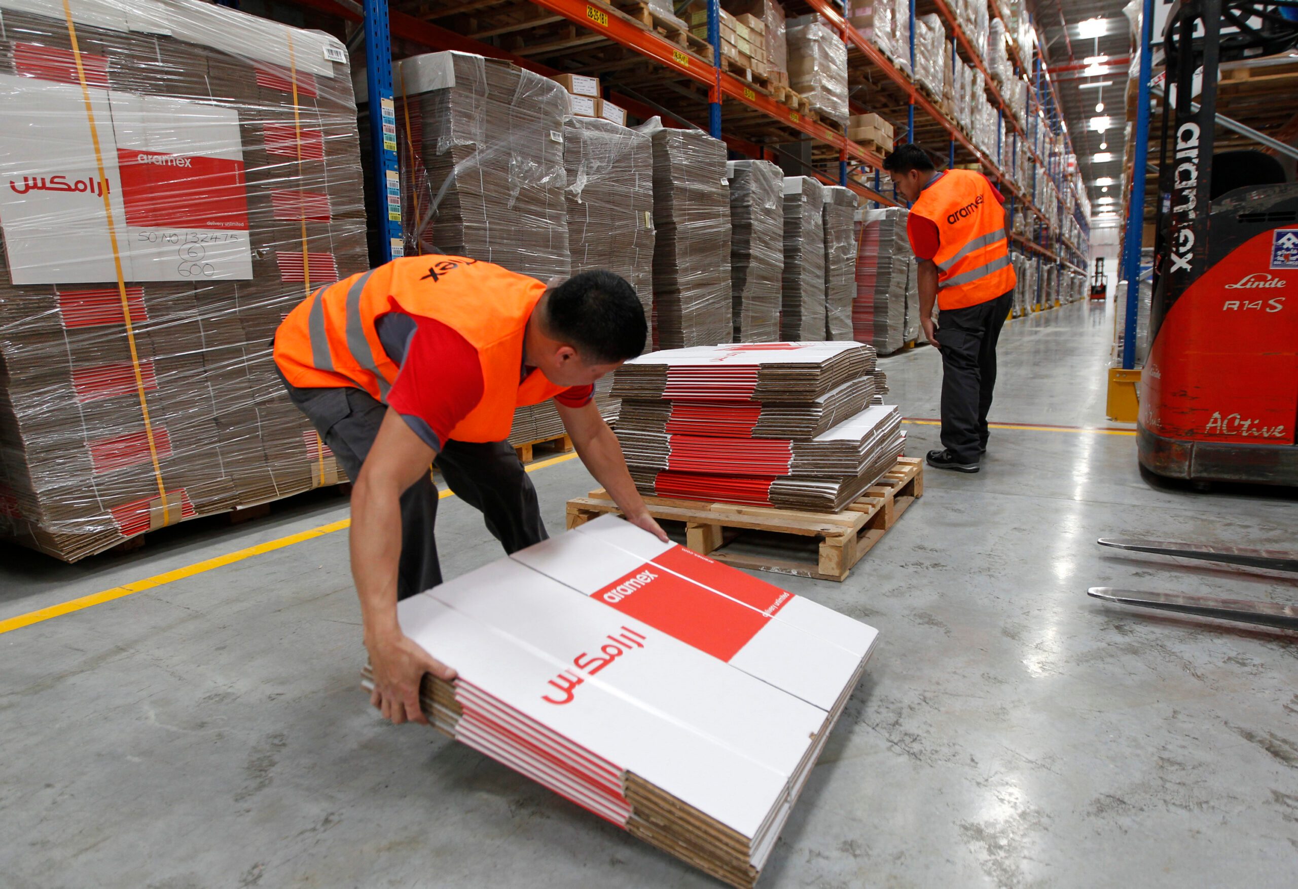 Workers load branded boxes at the distribution warehouse unit at the Aramex Emirates head offices and freight and logistics facility at Dubai Logistics City