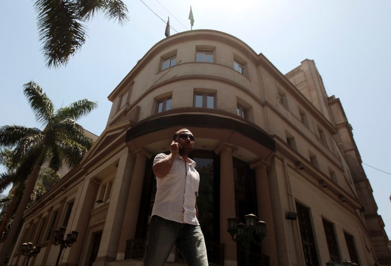 A man speaks on a mobile phone in front of the Egyptian Stock Exchange in Cairo