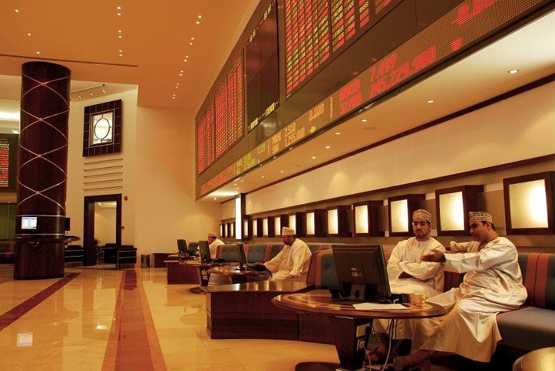 People sit at the Muscat Stock Exchange in Oman