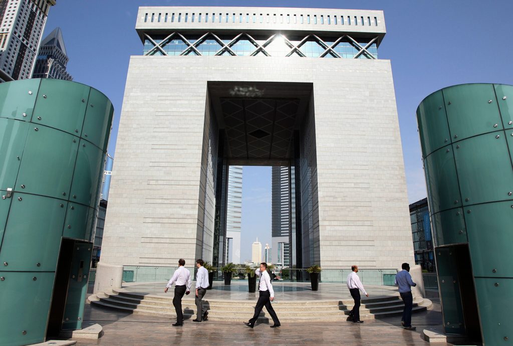 People walk outside the Gate Building at the Dubai International Financial Centre
