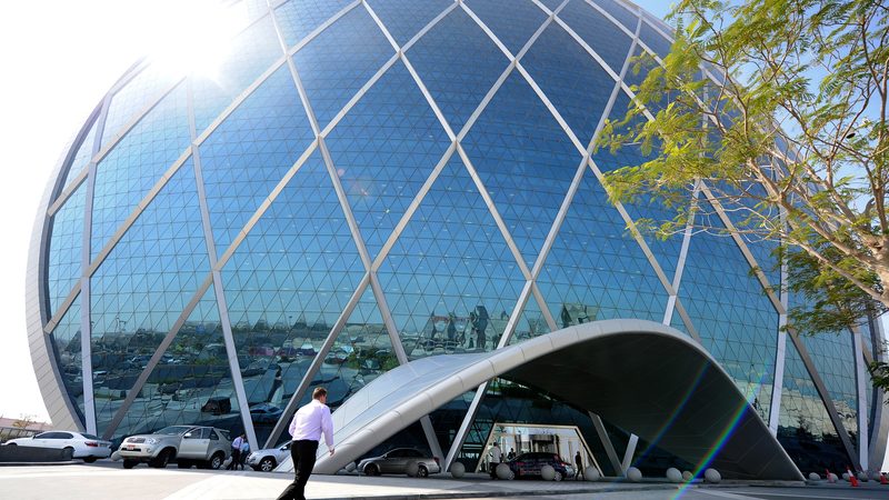 People walk past the headquarters of Aldar Properties at Al Raha Beach in Abu Dhabi,