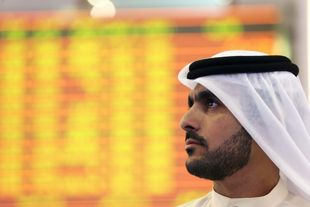 An Investor looks at the screen at the Dubai Financial Market in Dubai DFM