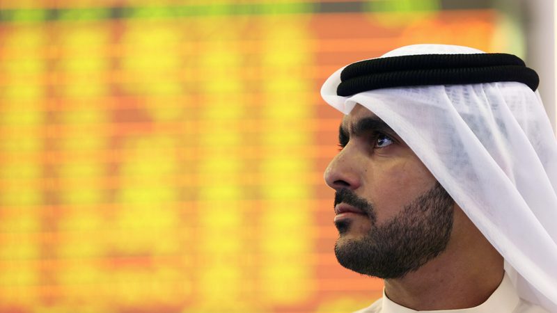 An Investor looks at the screen at the Dubai Financial Market in Dubai DFM