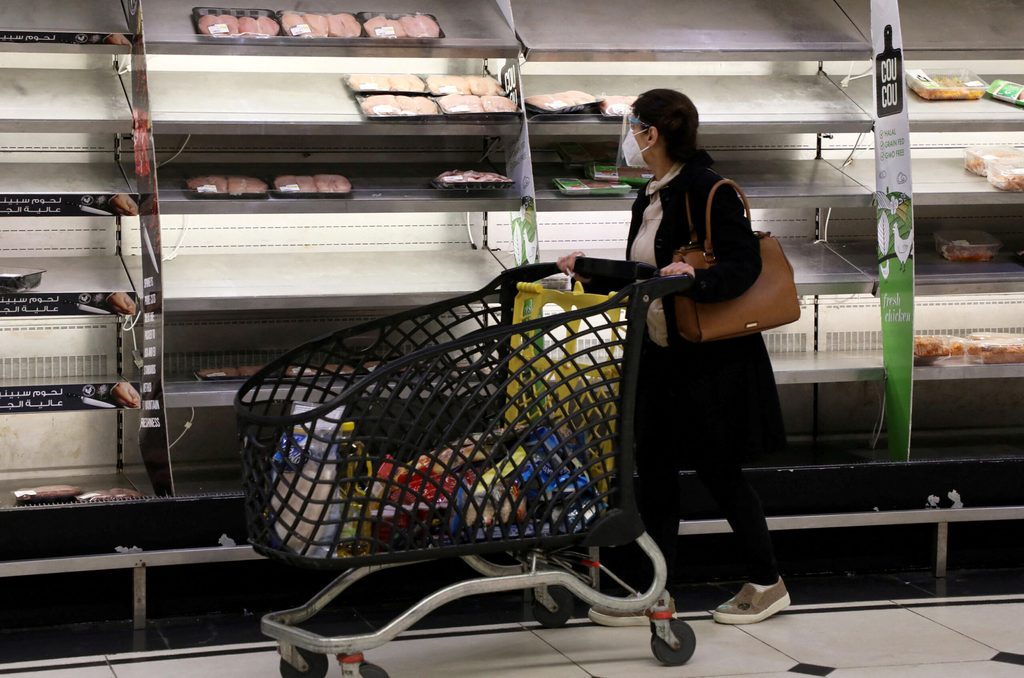 A shopper walks past near-empty shelves at a supermarket in Beirut, Lebanon