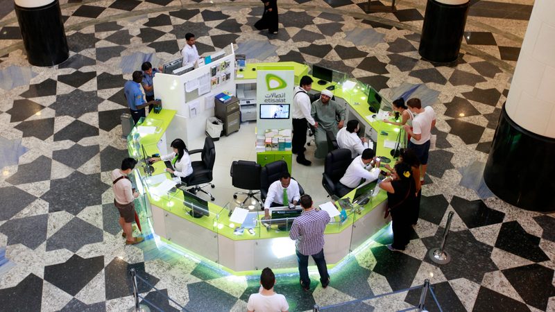 Customers queue at an Etisalat kiosk at a Dubai mall. The telecoms giant is in talks with Czech firm PPF Group