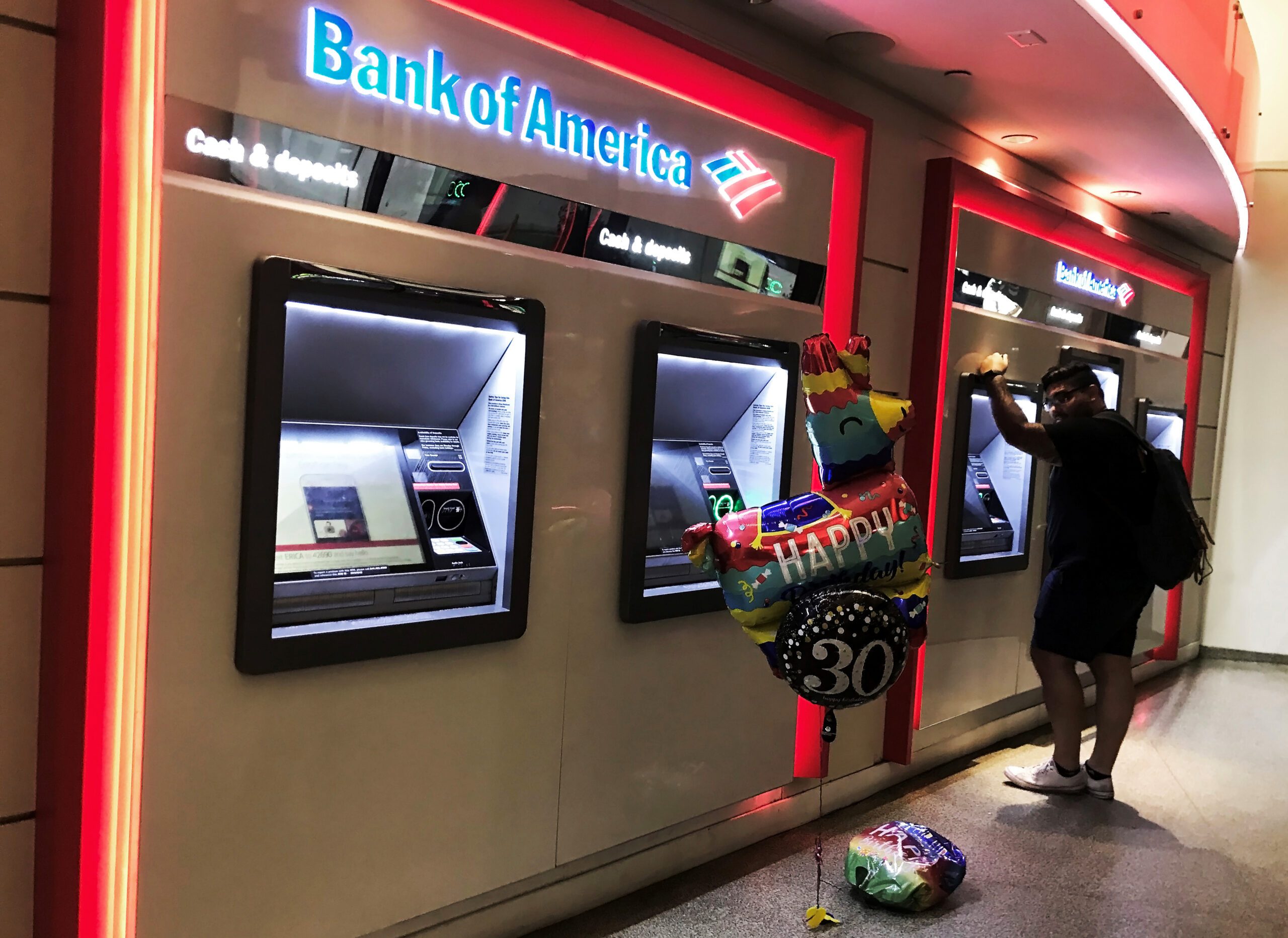A man uses a Bank of America cash dispenser. The bank advised on two multibillion-dollar mergers in H1 2023