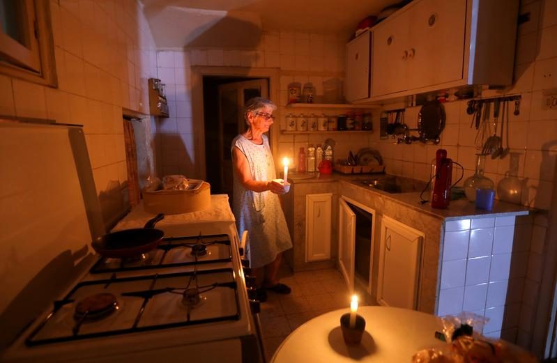 Lebanon energy crisis: Samira Hanna uses candles to light her kitchen during a power cut in Beirut