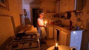 Lebanon energy crisis: Samira Hanna uses candles to light her kitchen during a power cut in Beirut
