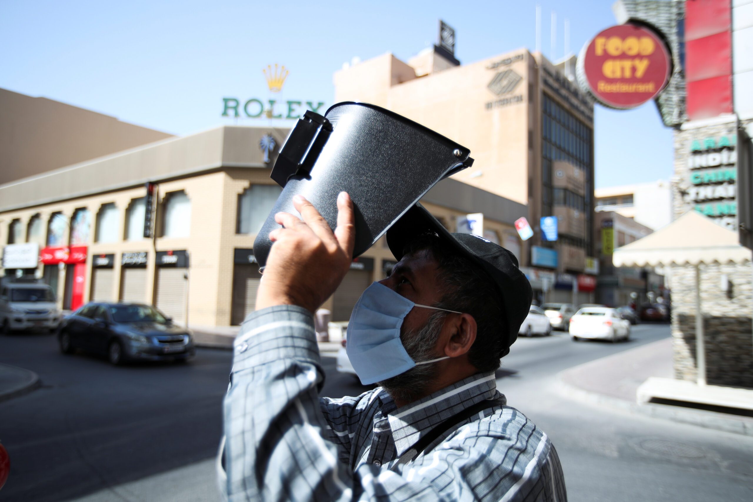 A man in Manama, Bahrain, uses a welding mask to watch a solar eclipse. In 2021 just 0.1 percent of Bahrain's total electricity generating capacity came from renewables