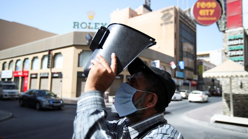A man in Manama, Bahrain, uses a welding mask to watch a solar eclipse. In 2021 just 0.1 percent of Bahrain's total electricity generating capacity came from renewables