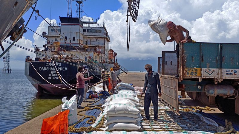 Labourers unload rice; restrictions may result in higher inflation