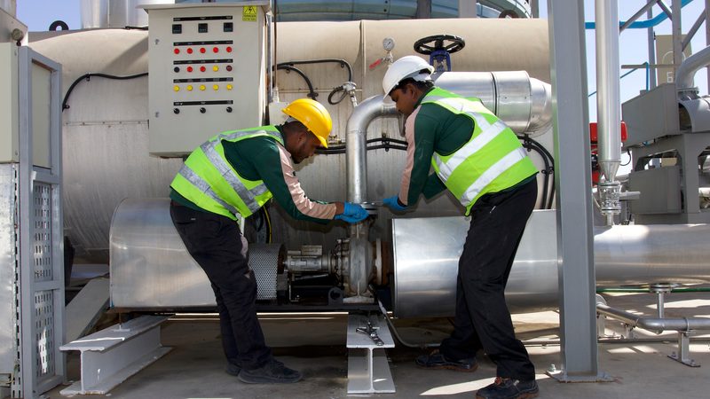 Lootah workers inspect the machines that turn used cooking oil into biofuel