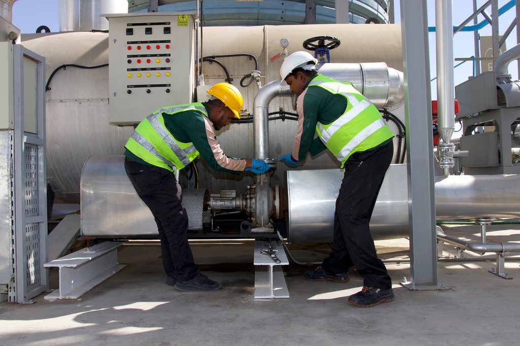 Lootah workers inspect the machines that turn used cooking oil into biofuel