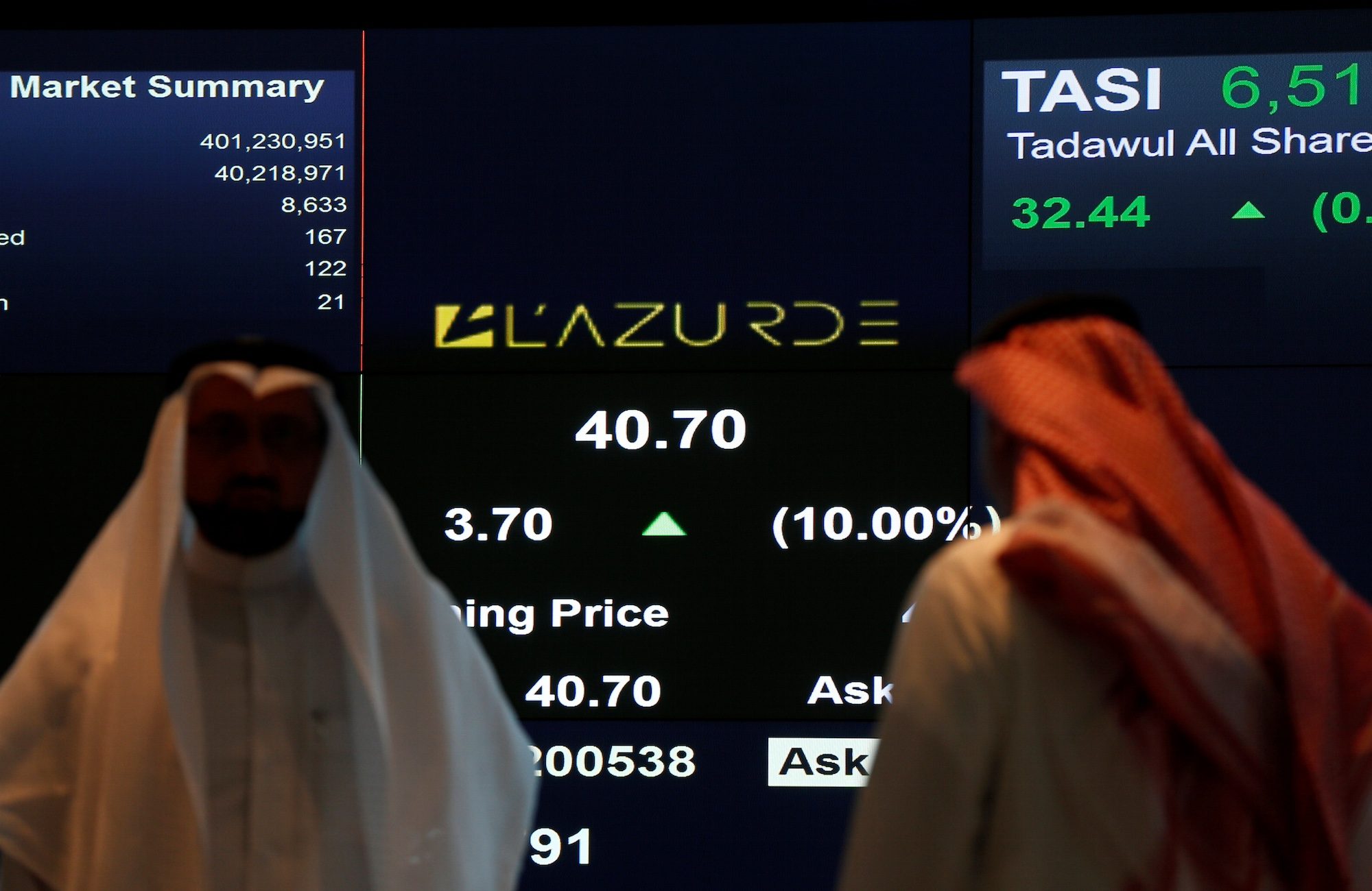 Traders monitor a screen showing stock information at the Tadawul in Riyadh
