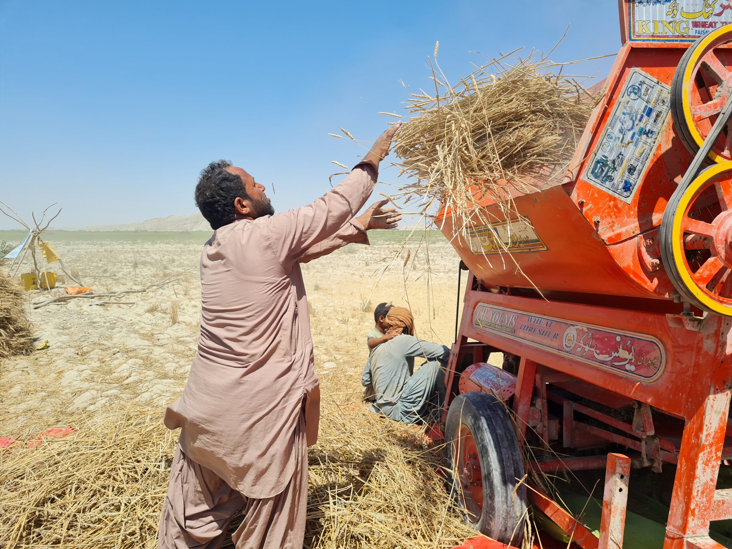 A farmer in a field next to machinery