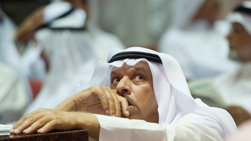 Hoping for a rebound: an investor keeps track of prices at the Kuwaiti bourse