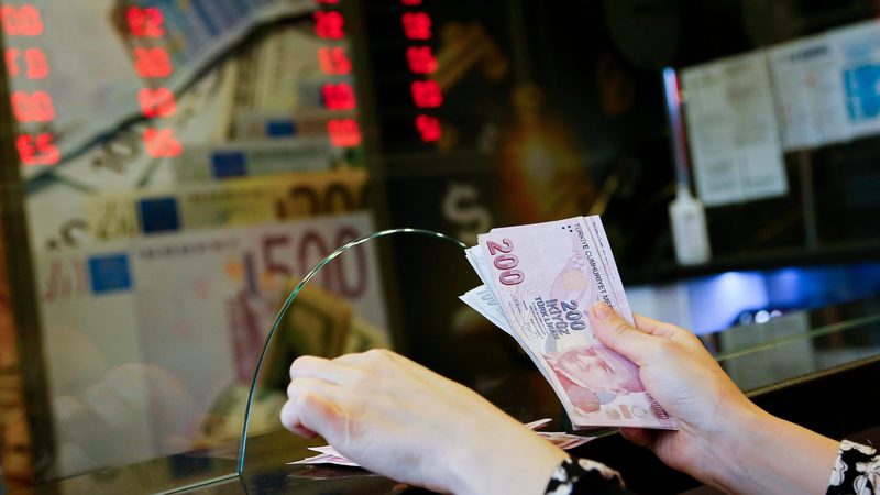 A worker counts Turkish lira at a currency exchange in Ankara. S&P Global Ratings this month upgraded Turkey to 'stable' from 'negative'