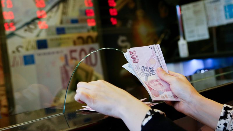 A worker counts Turkish lira at a currency exchange in Ankara. S&P Global Ratings this month upgraded Turkey to 'stable' from 'negative'