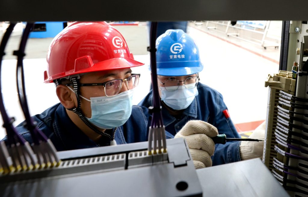 Workers inspect equipment at a hydropower plant in Zhangye, northern China. About 41% of renewables jobs are in China