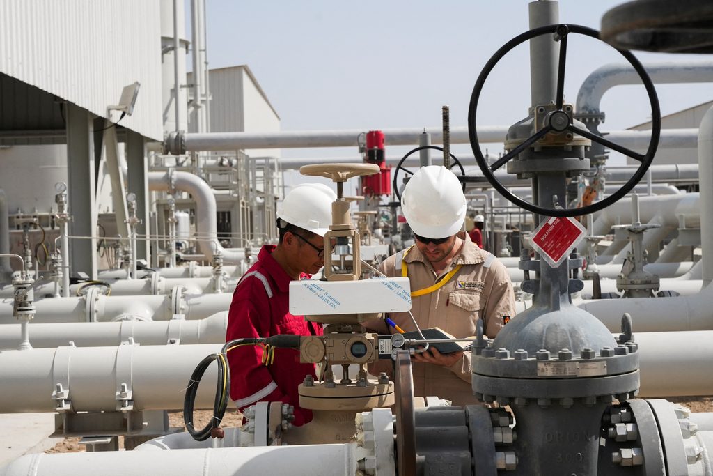 Workers at Majnoon oil field in Iraq. Analysts do not expect the conflict to have a big effect on oil supply