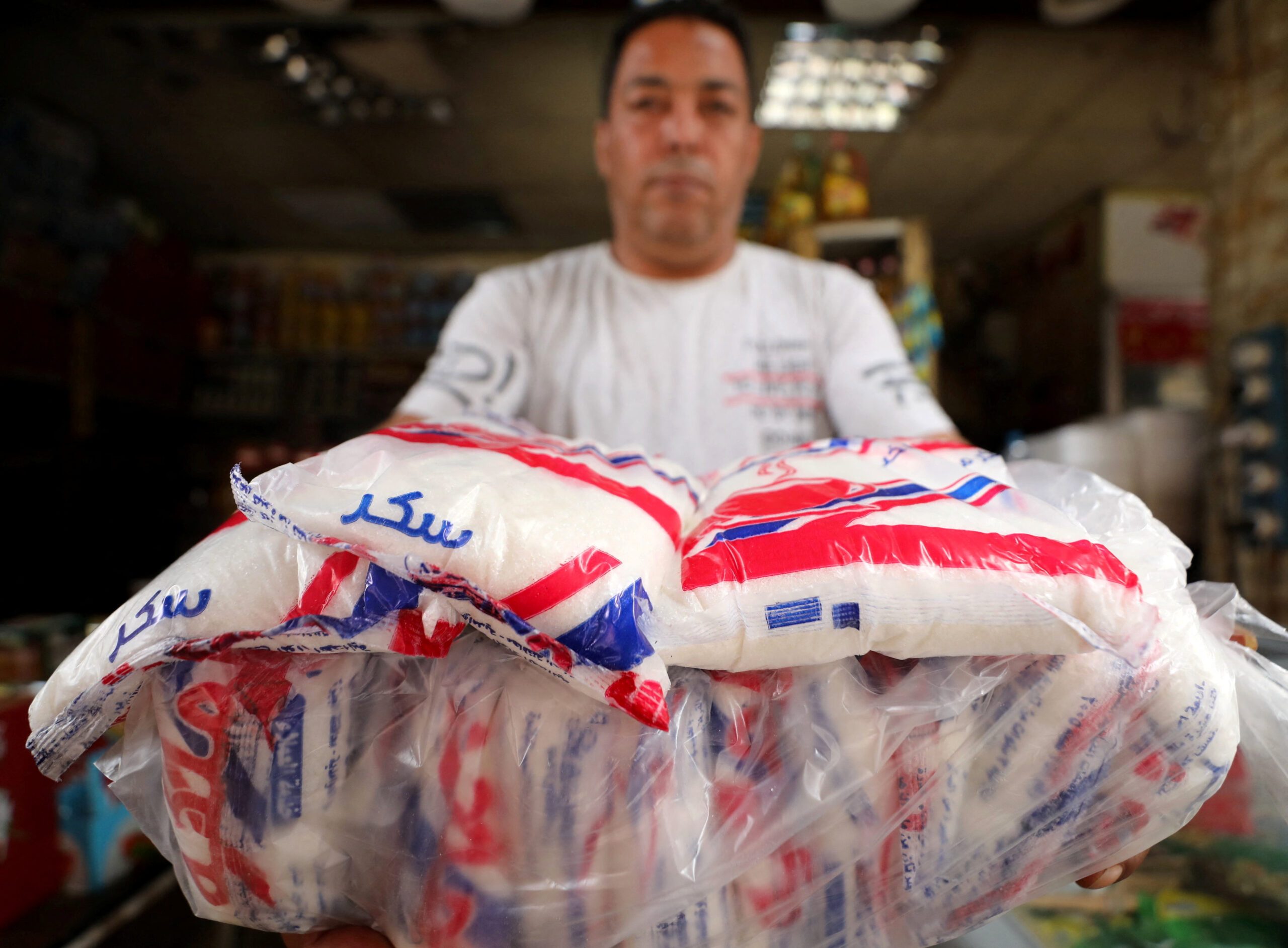 A seller with packs of sugar at a market in Cairo. The Egyptian government recently announced it would lower the prices of seven essential commodities