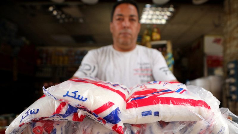 A seller with packs of sugar at a market in Cairo. The Egyptian government recently announced it would lower the prices of seven essential commodities