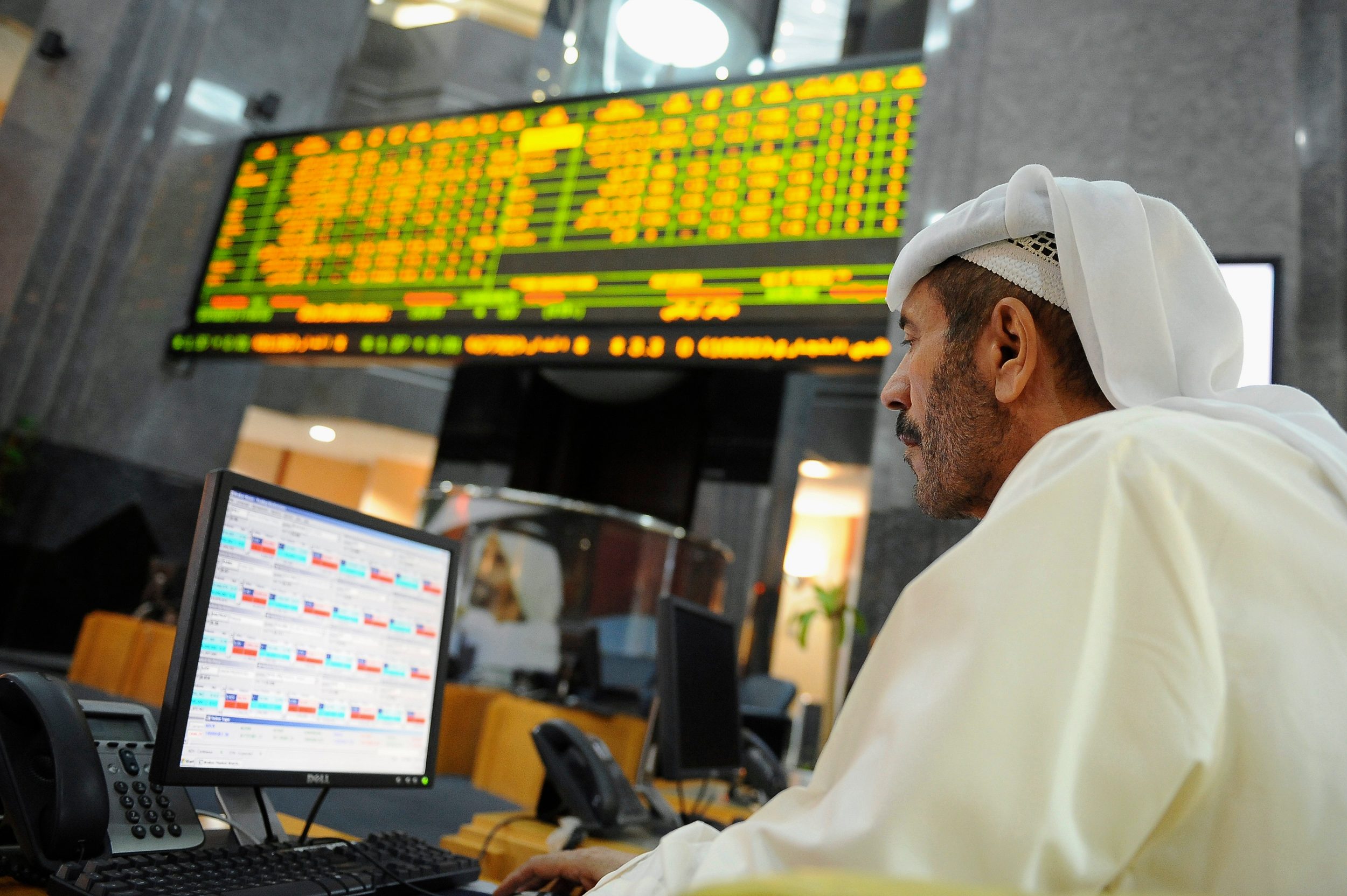 An investor studies a screen at the Abu Dhabi Securities Exchange