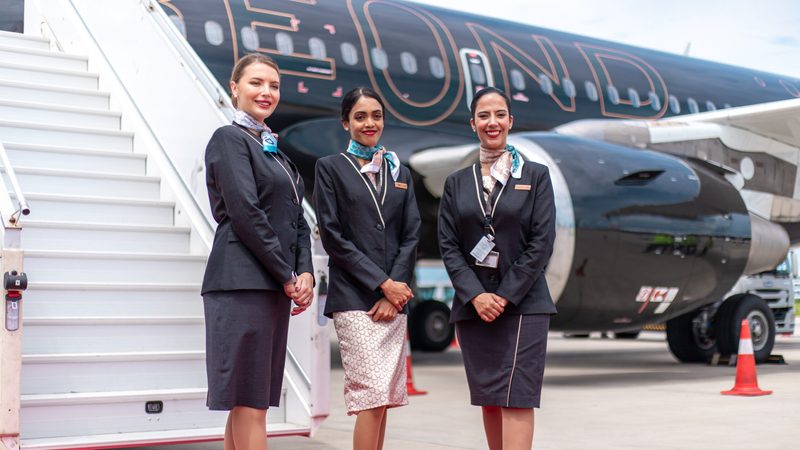 Three female Beond cabin crew stand at the steps of an aircraft luxury leisure airline Beond aims to make the flight an enjoyable element of the leisure experience