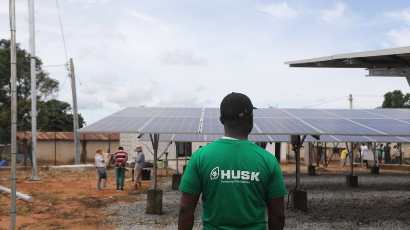 A Husk Power employee stands next to solar panels at the company's minigrid in Kiguna, Nasarawa, Nigeria