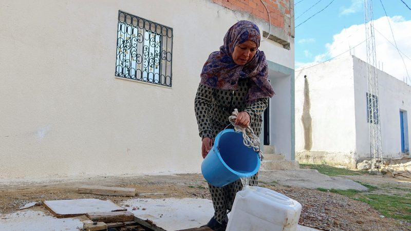 A woman collects water from a well in Tunis. Tunisia is having to operate a quota system for tap water