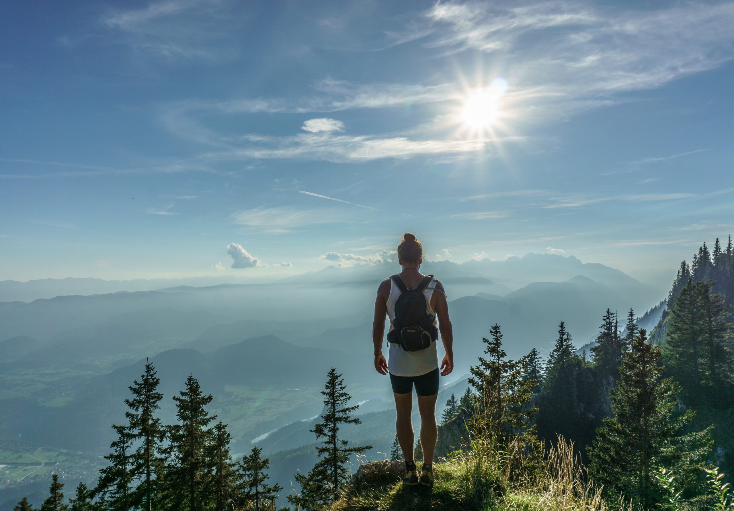 Woman in forest with sun shining