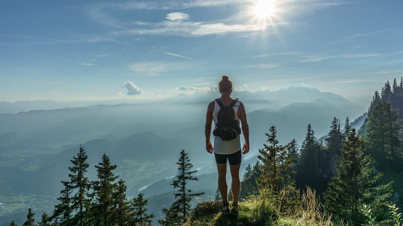 Woman in forest with sun shining