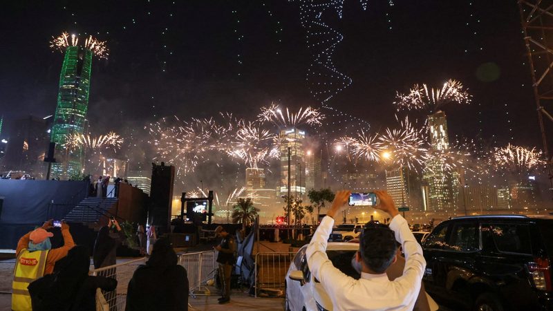 People watch fireworks and a light show as Saudi Arabia celebrates winning its bid to host the World Expo 2030 in Riyadh