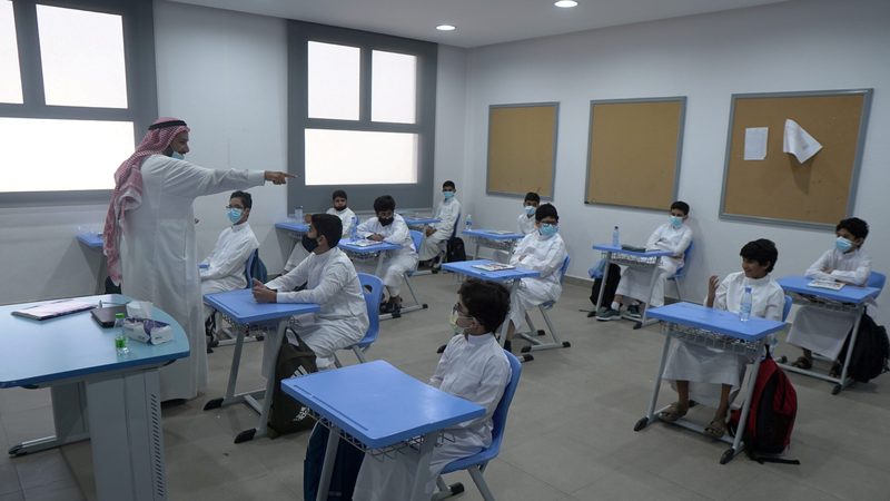 Masked and socially distanced pupils at a Saudi school in 2021. The OECD's Pisa tests show the impact of the pandemic on education