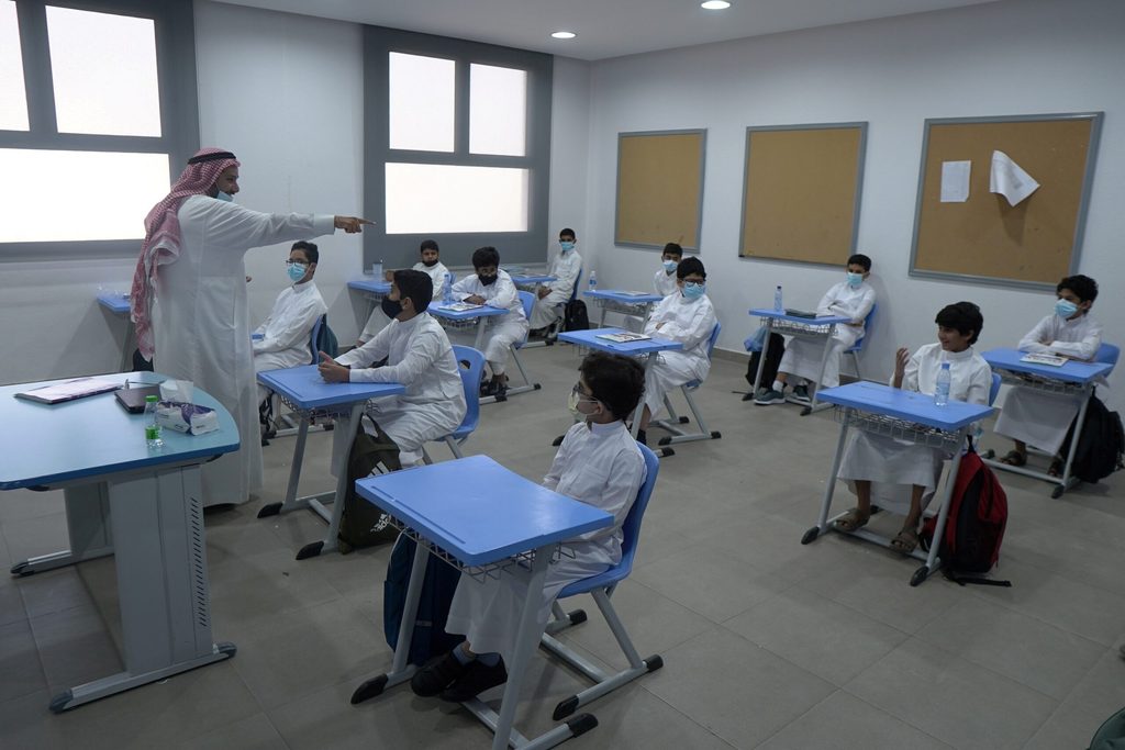 Masked and socially distanced pupils at a Saudi school in 2021. The OECD's Pisa tests show the impact of the pandemic on education