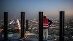 A worker looks out at Riyadh from a tower under construction in the city